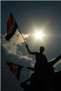متظاهر يرفع علم الحرية