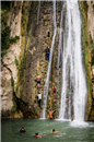 people climb waterfall